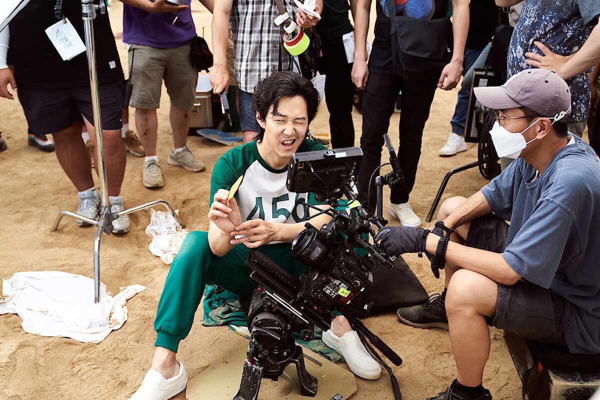 Lee Jung-jae as Player 456 filming a scene with dalgona candy on the set of Squid Game.