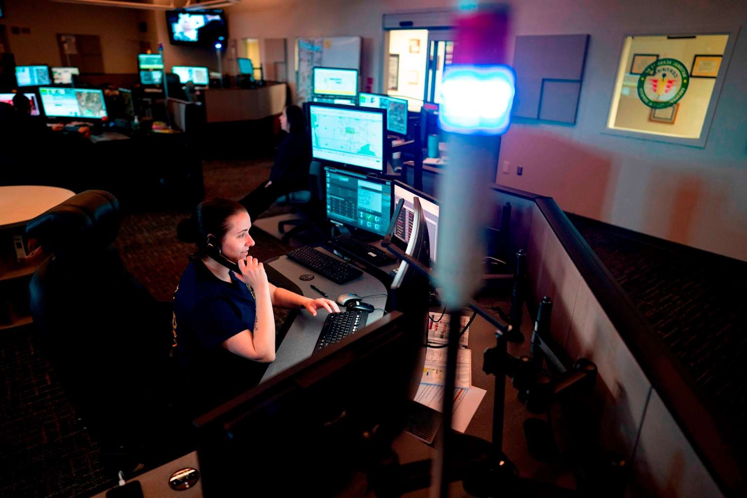 An emergency command center with operators monitoring data and communicating during a cyberattack response