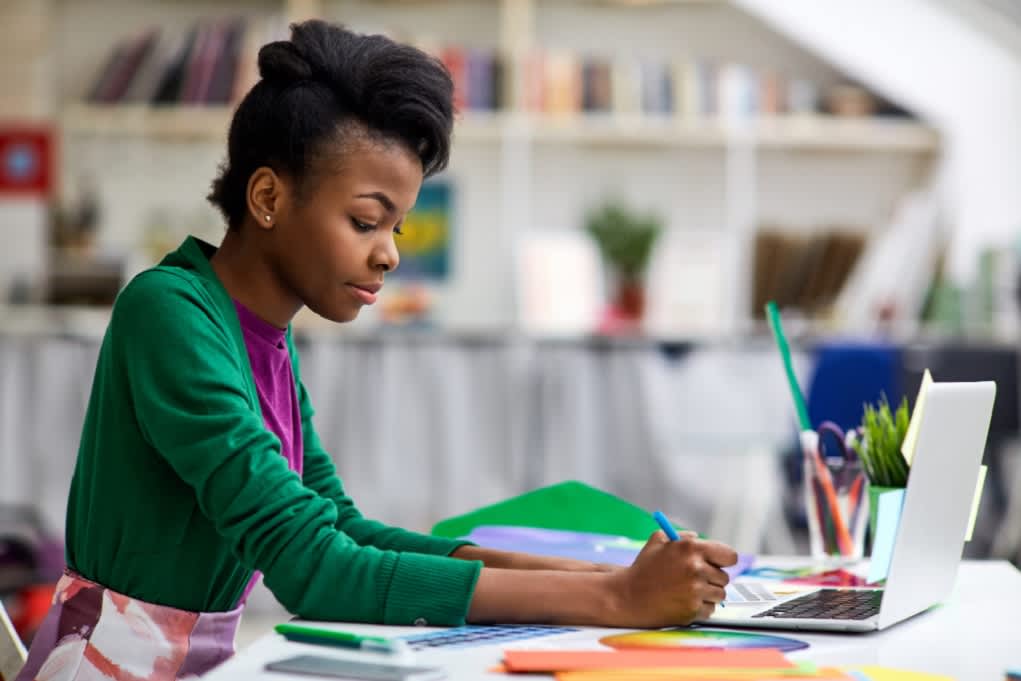 Student studying with laptop and books