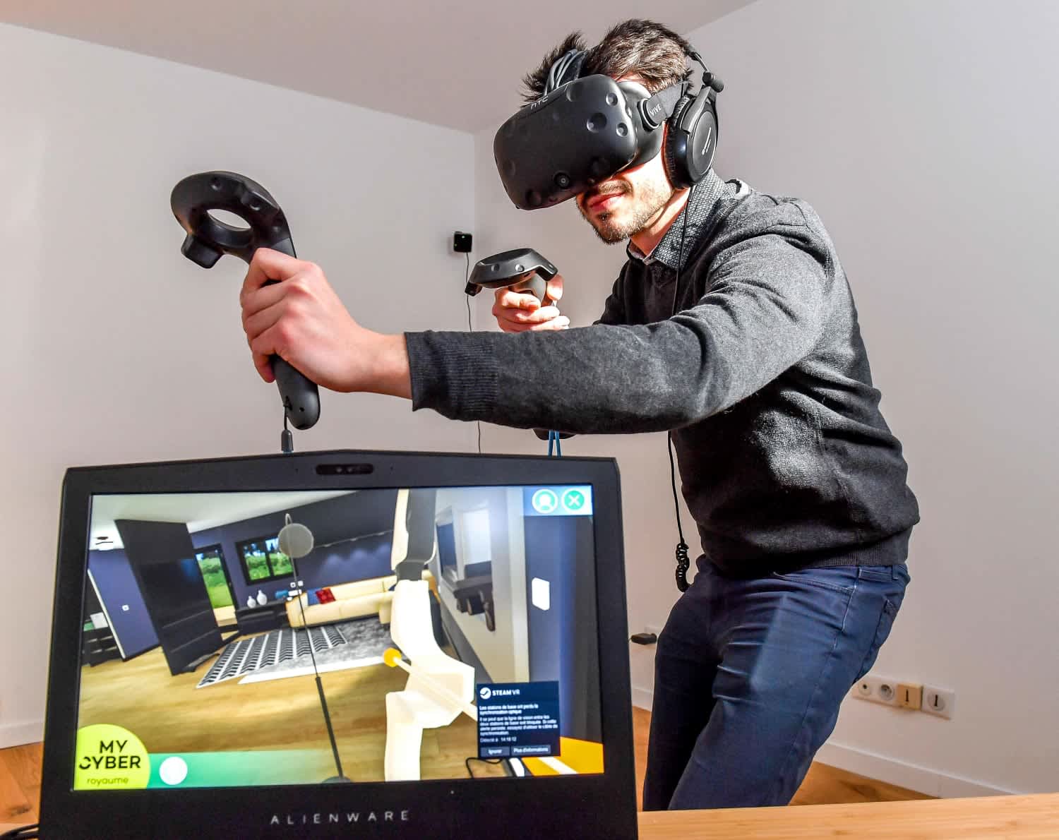 A man interacts with a virtual environment using a VR headset and controllers