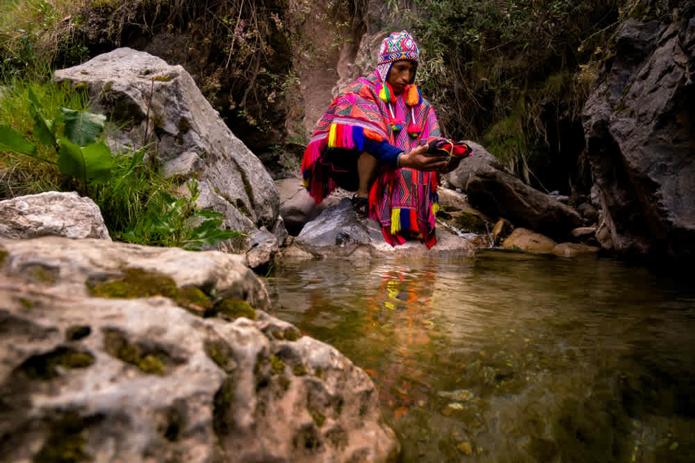 Person in traditional clothing performing water ceremony