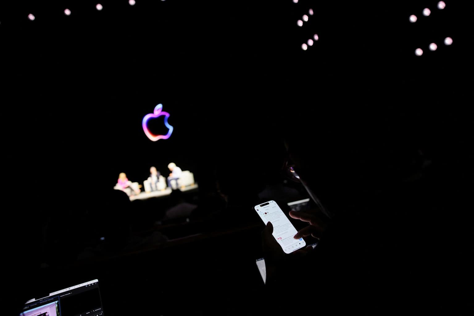 An attendee uses their phone during an Apple WWDC keynote event.