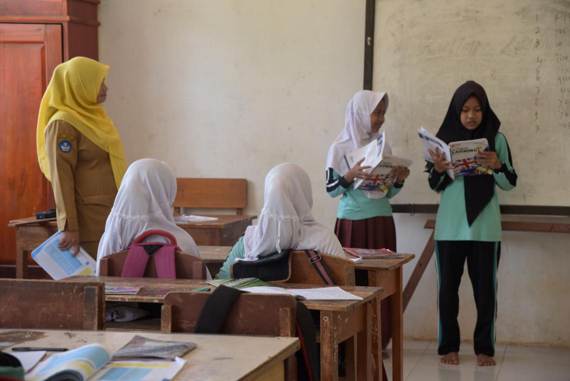 Guru berjilbab mengajar siswa di kelas