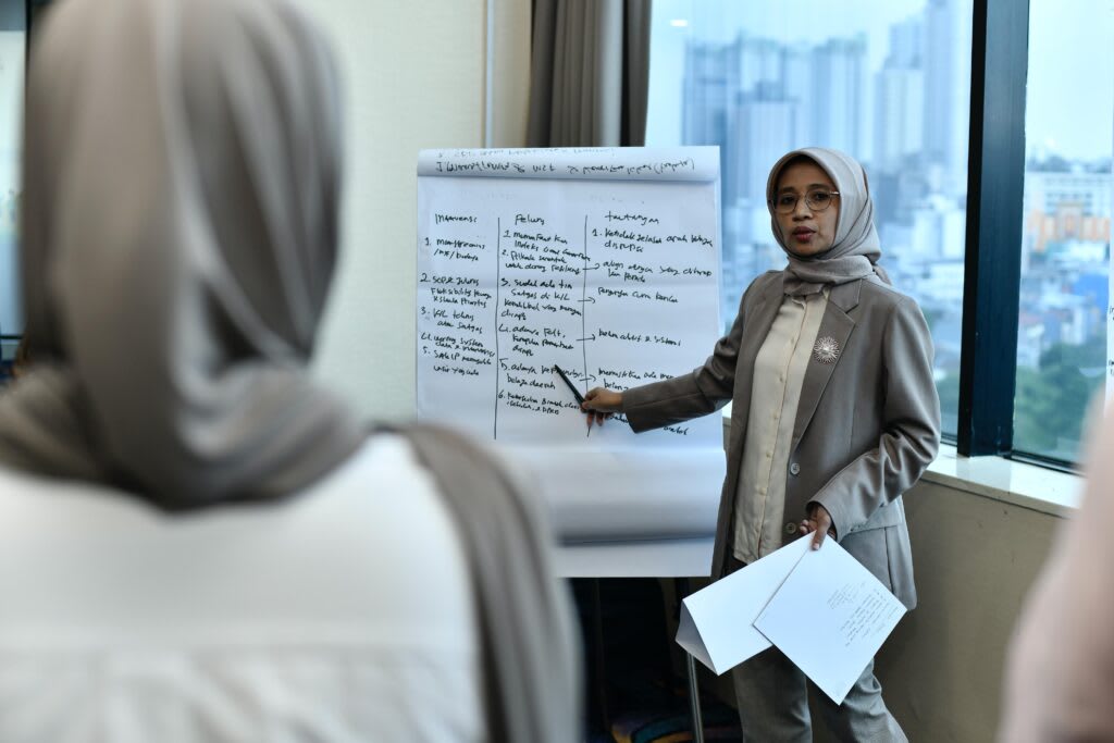 Guru sedang menjelaskan materi di papan tulis