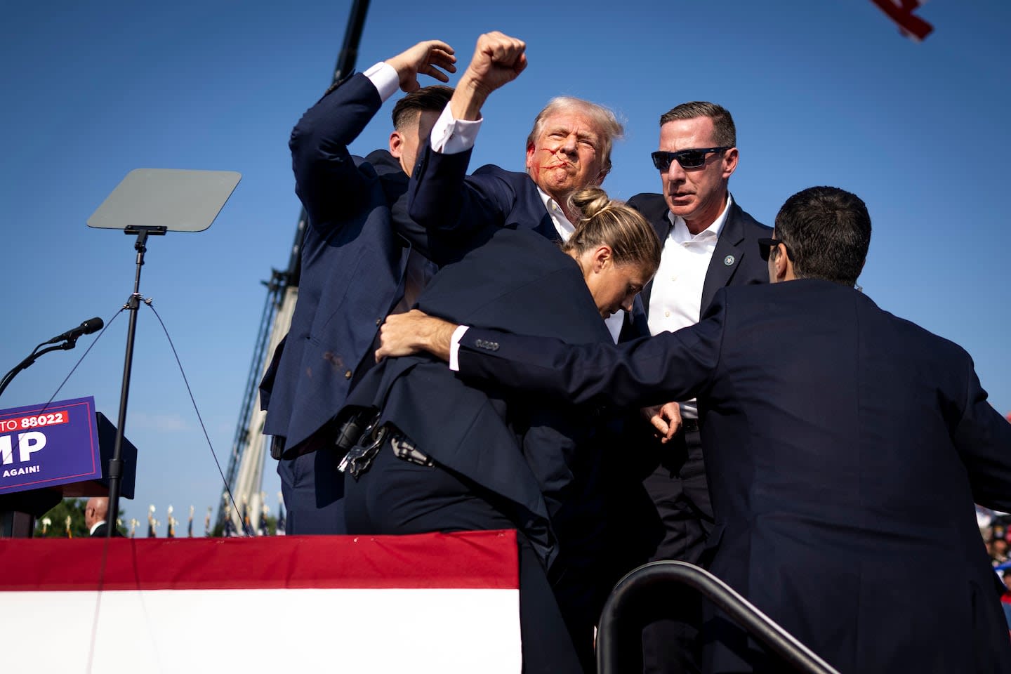 Former President Donald Trump raising his fist amid a security incident at a political rally
