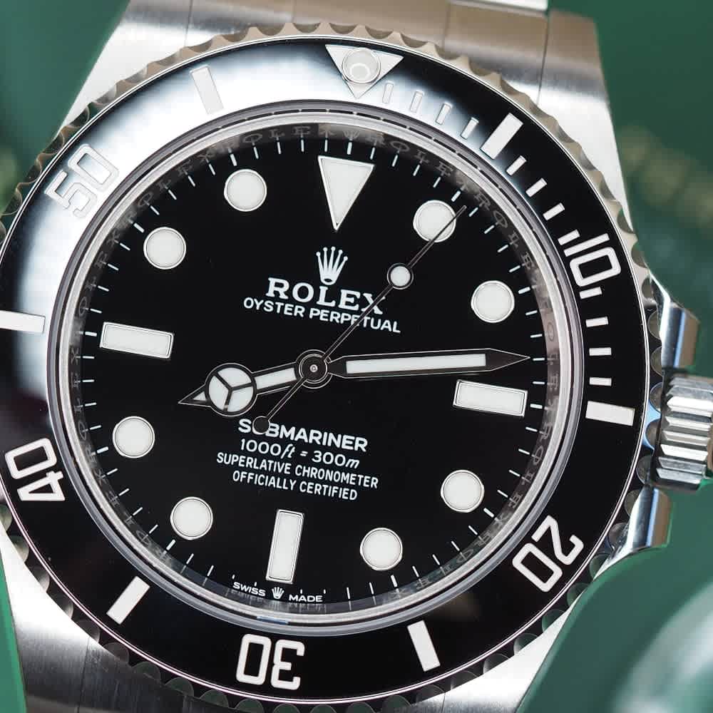 A close-up view of the black dial and ceramic bezel of a modern Rolex Submariner 124060 watch