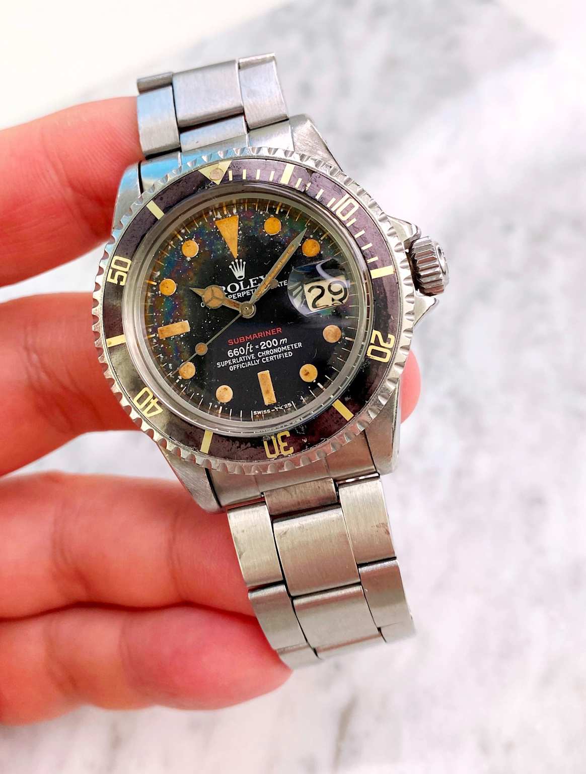 A vintage Rolex Submariner Reference 1680 "Red Submariner" with a tropical dial and aged luminous markers