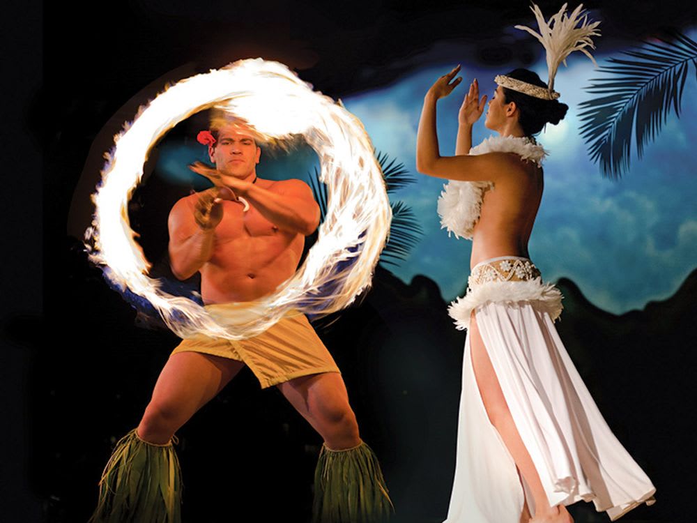 Traditional Hawaiian luau featuring a fire dancer and hula performer showcasing cultural heritage and entertainment