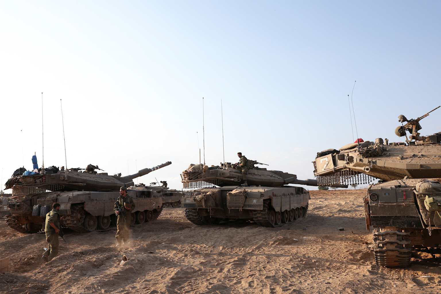 Military tanks and soldiers in a desert setting reflecting heightened Middle East tensions amid ongoing conflict