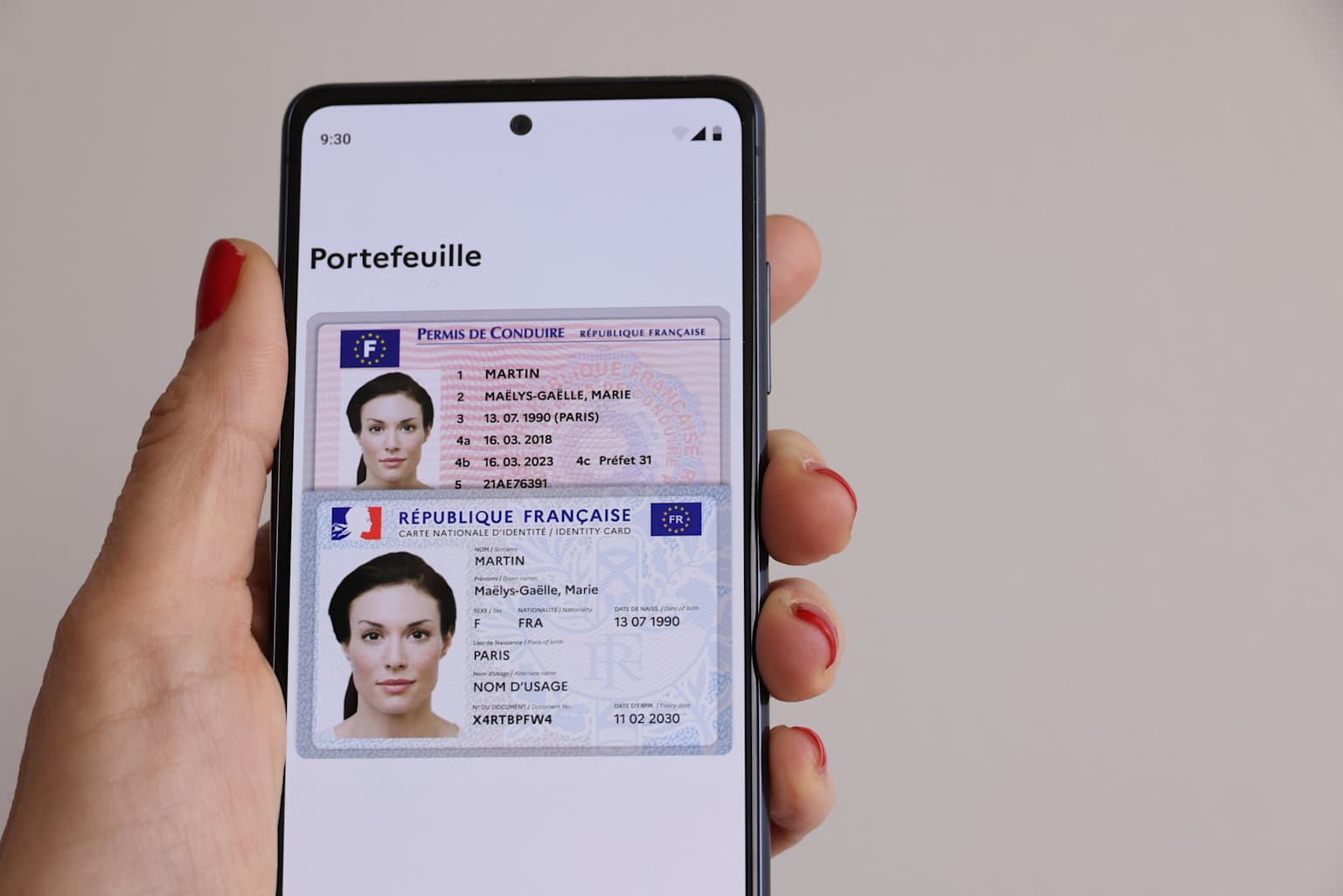 Un smartphone affichant un permis de conduire numérique français et une carte nationale d’identité au sein d’une application de portefeuille numérique.