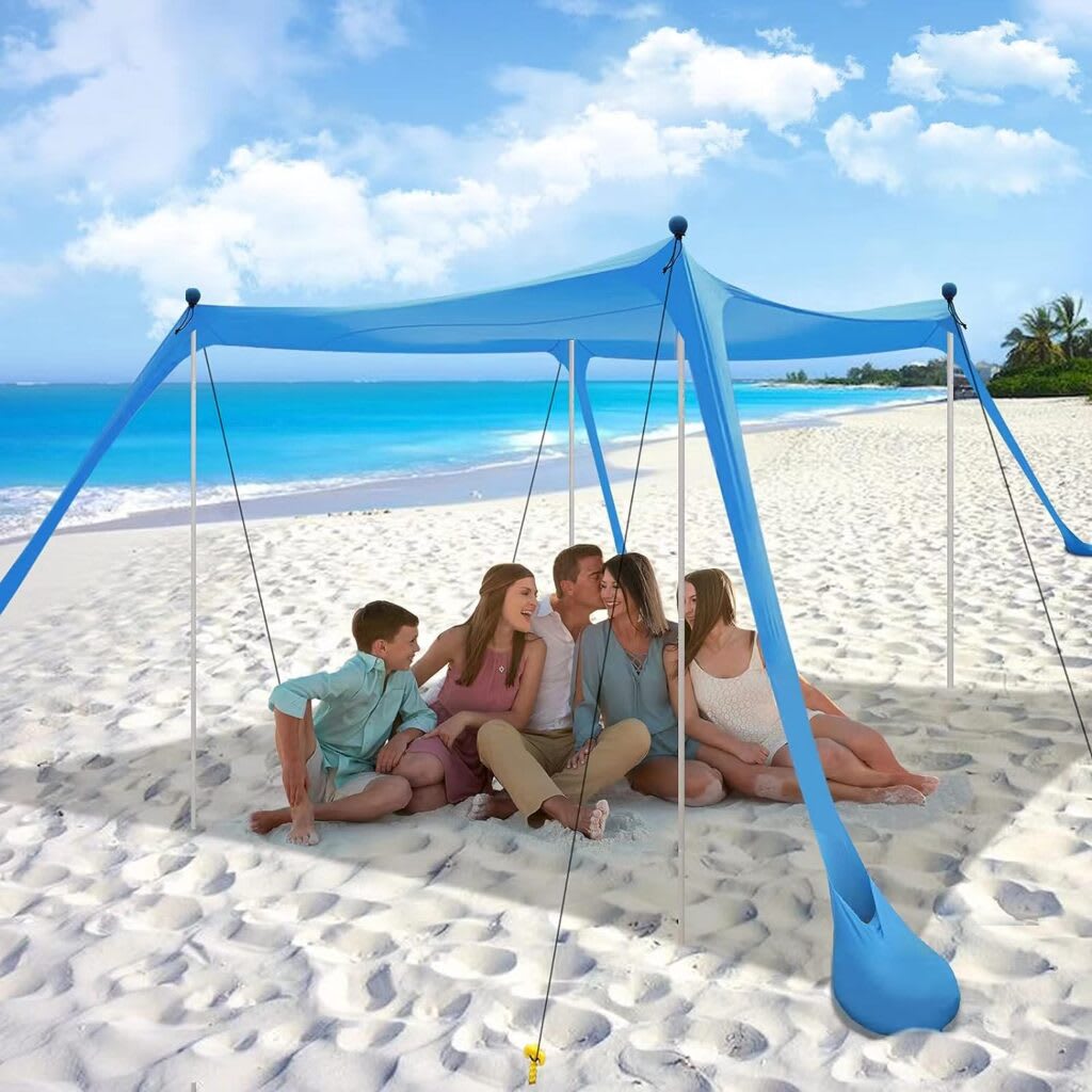 A family relaxes under a blue sun shelter on a sunny white sand beach
