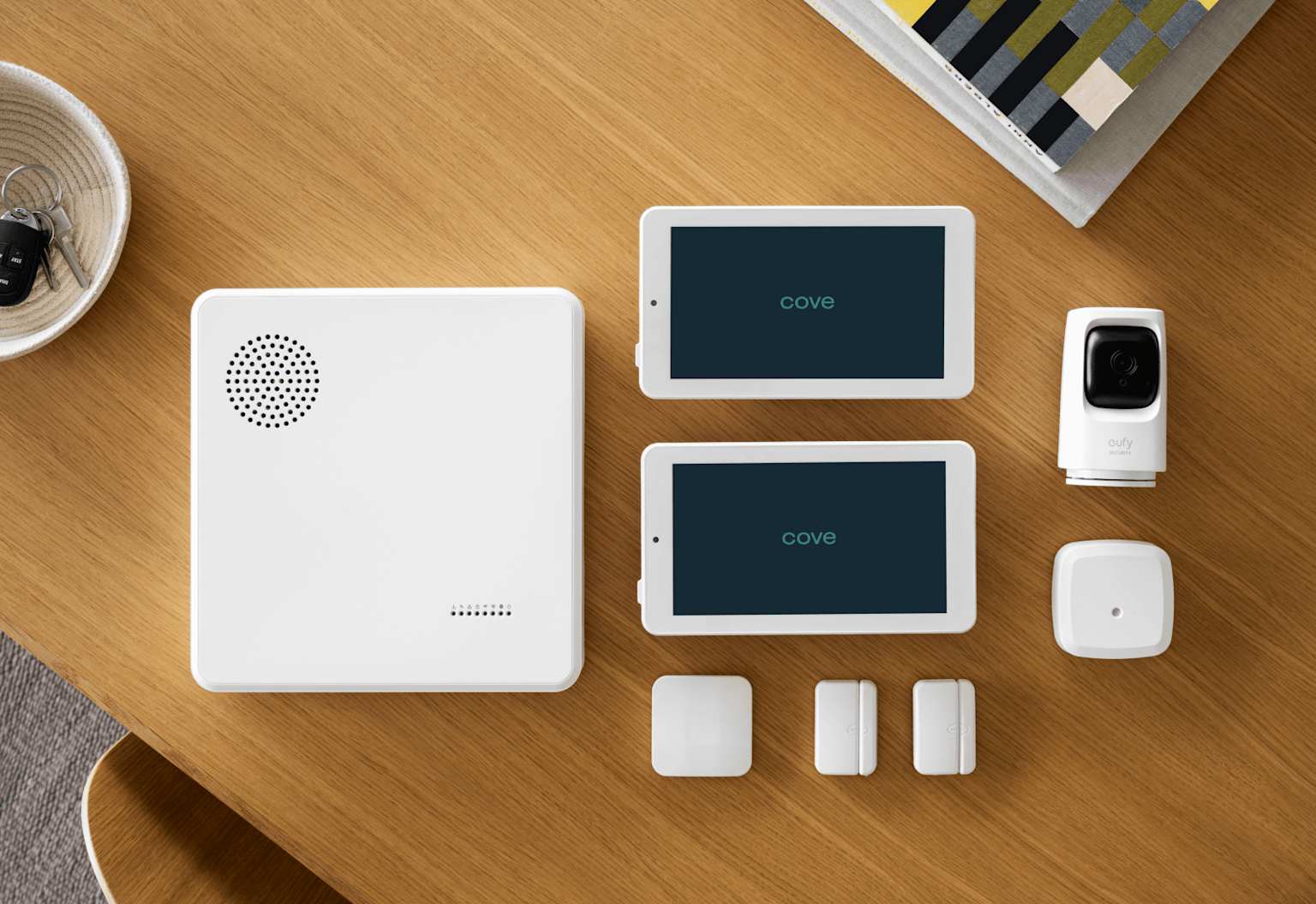 A modern home security system featuring a central hub, control tablets, a security camera, and various sensors for comprehensive protection