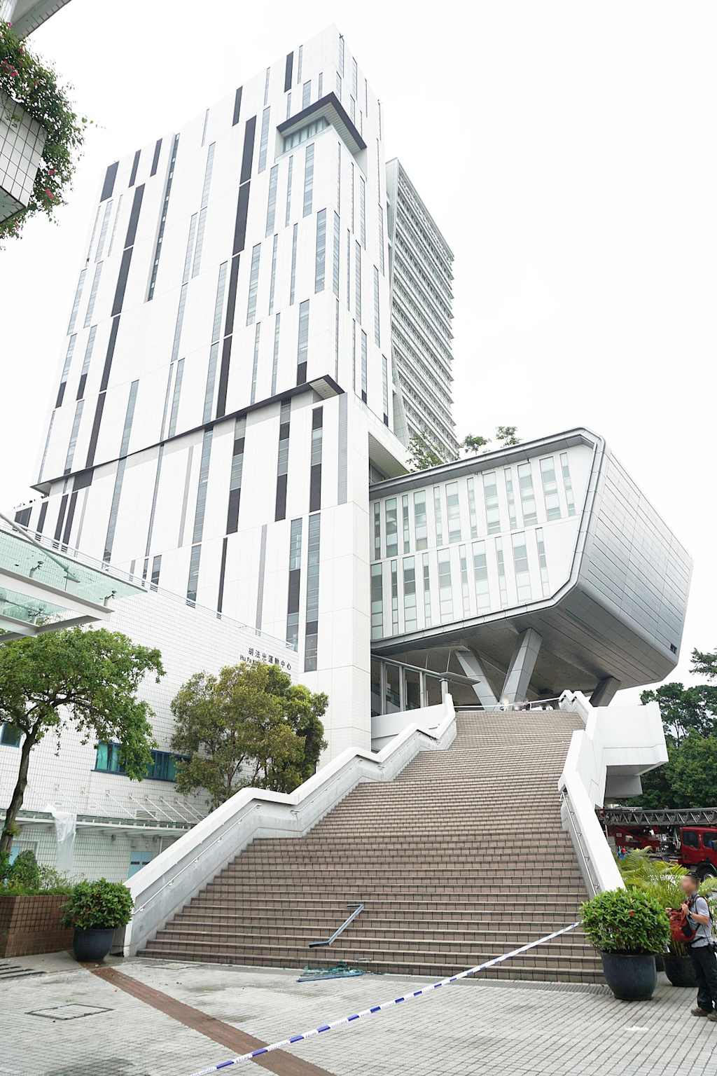 Exterior view of the Hu Fa Kuang Sports Centre at City University of Hong Kong, featuring modern architecture and a grand entrance staircase