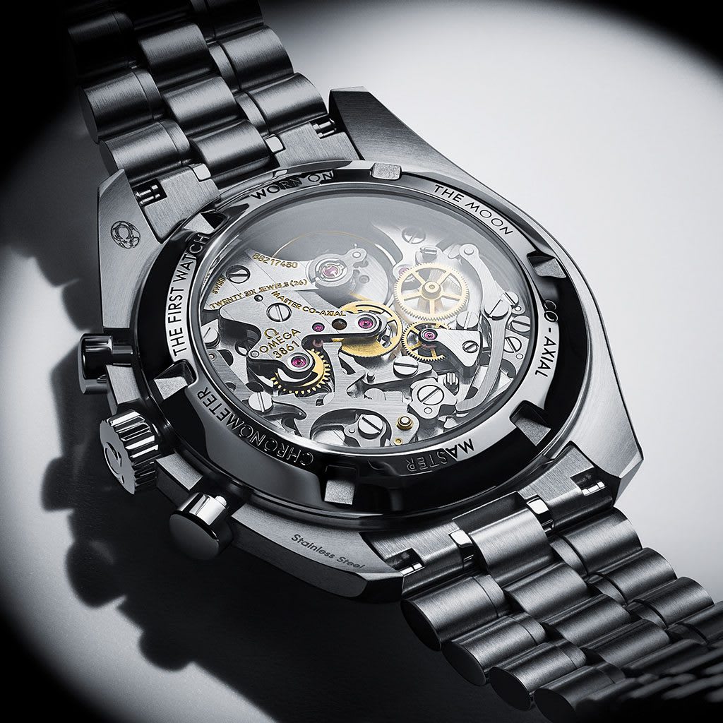 The transparent case back of an OMEGA Speedmaster Moonwatch Professional reveals its intricate mechanical movement and historical engravings