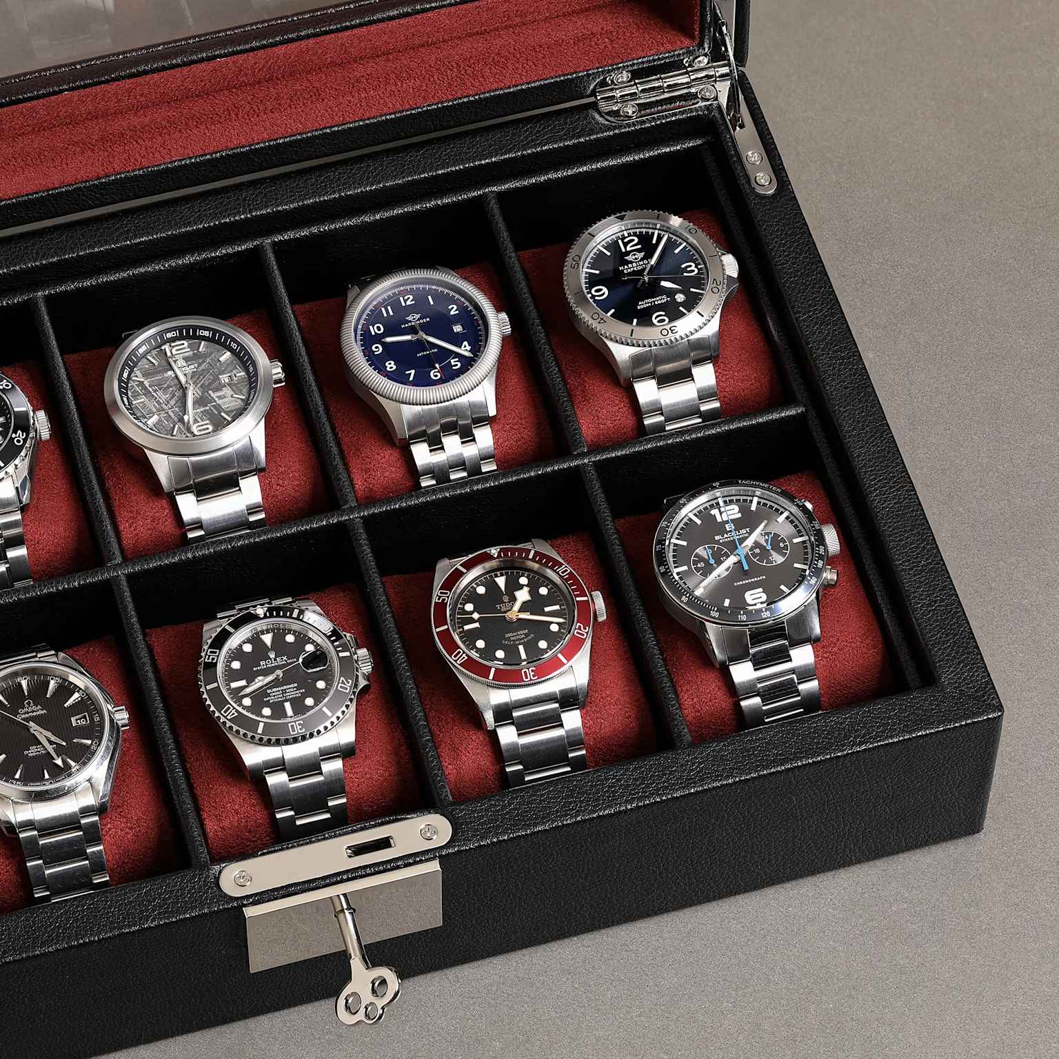 A collection of luxury watches, including an Omega Seamaster, stored in a red-lined leather watch box