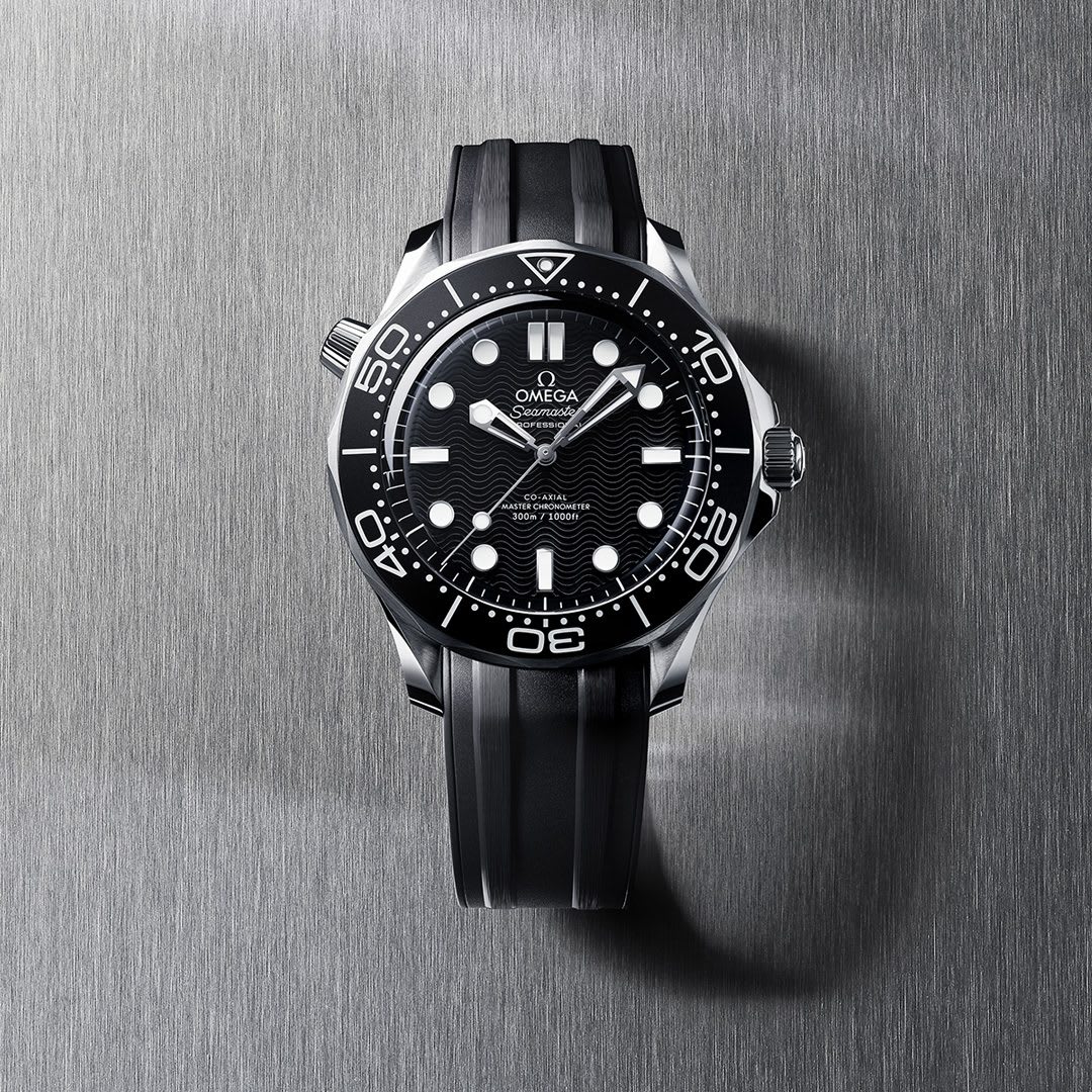 The OMEGA Seamaster Diver 300M Master Chronometer watch with a black dial and rubber strap on a brushed metal background