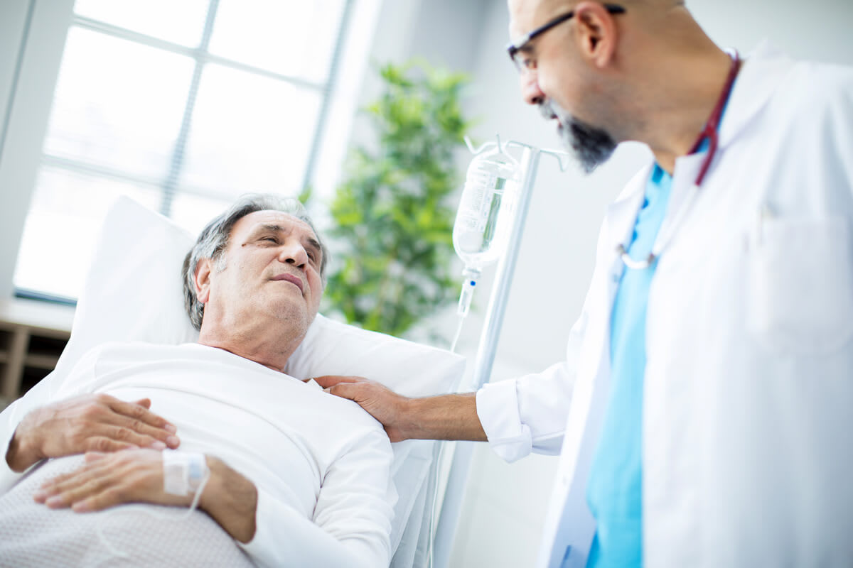 A doctor provides comfort and care to a patient recovering in a hospital bed