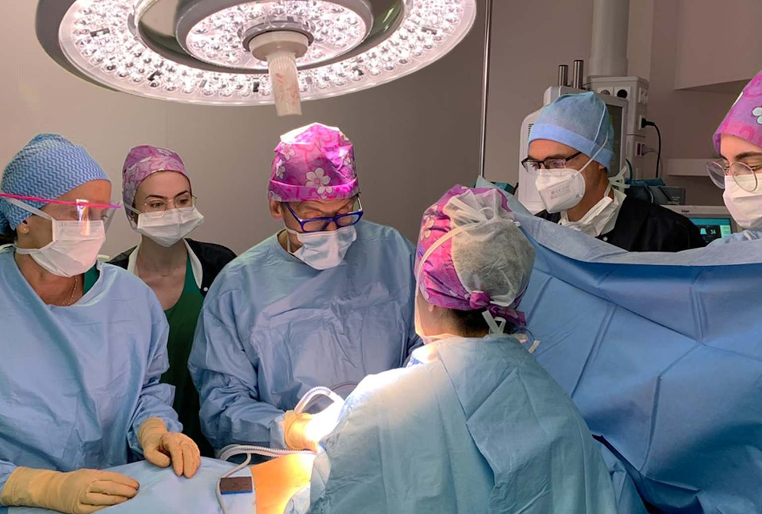 A surgical team performing an operation in a brightly lit operating room