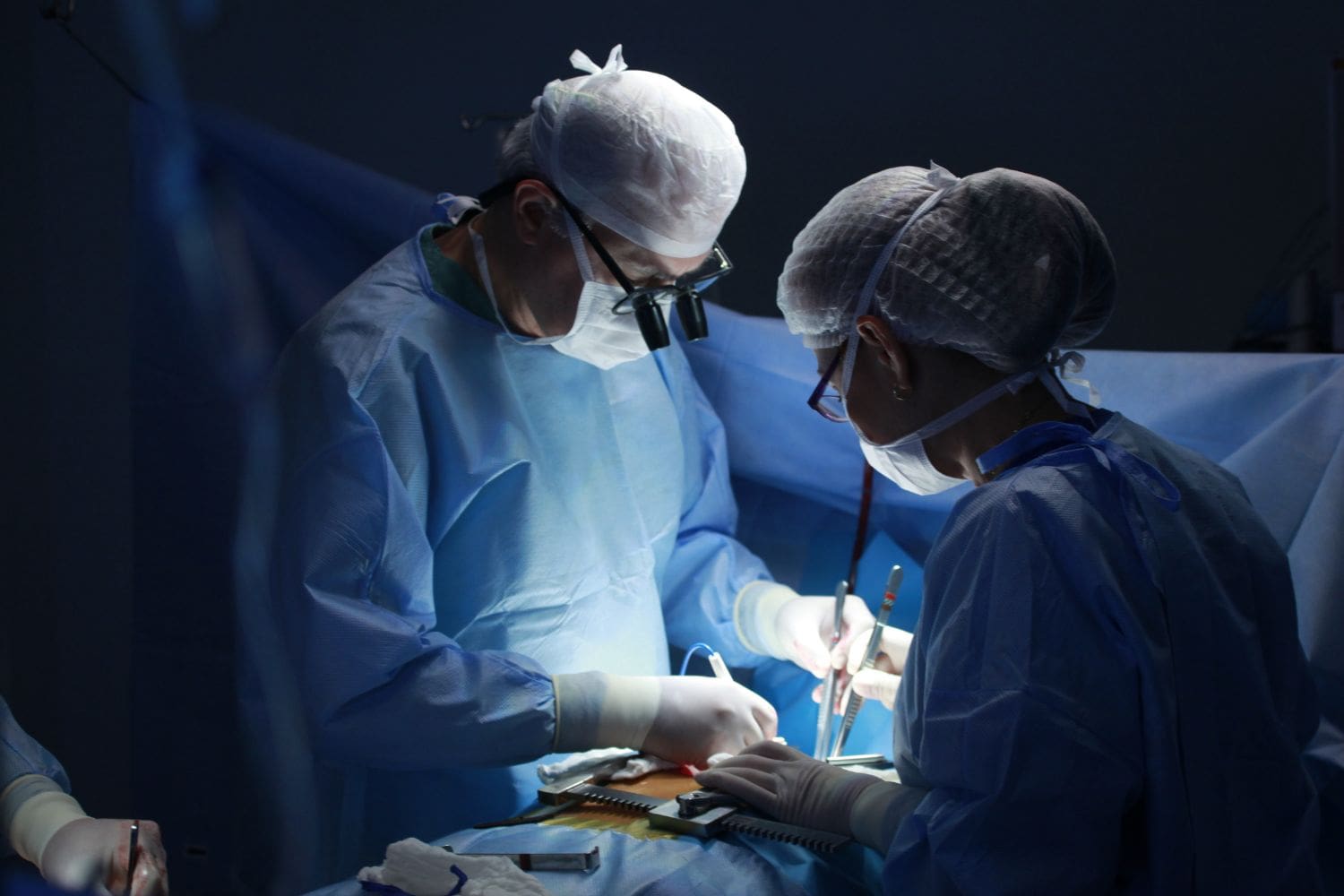 Surgeons performing an operation in an operating room, illustrating the surgical aspect of oncology treatment