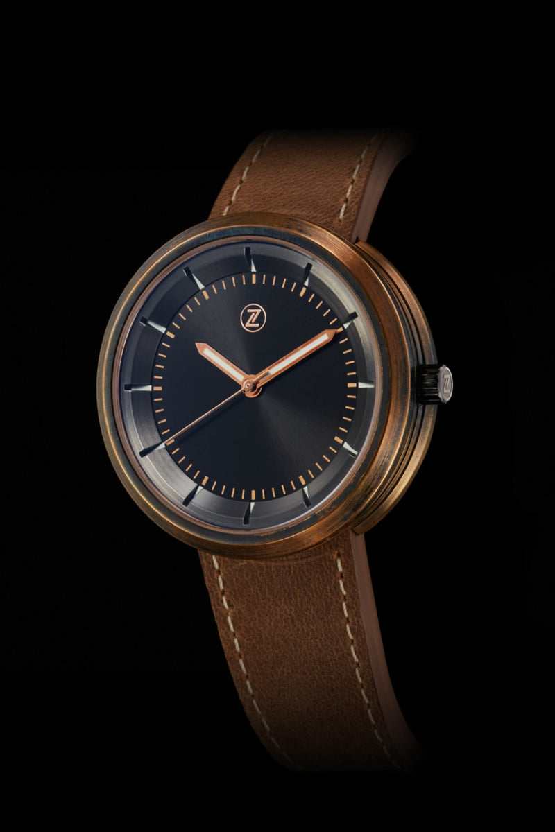 A Zelos Chroma 2 Limited Edition bronze watch with a dark dial and brown leather strap, showcasing a typical offering from a microbrand watchmaker