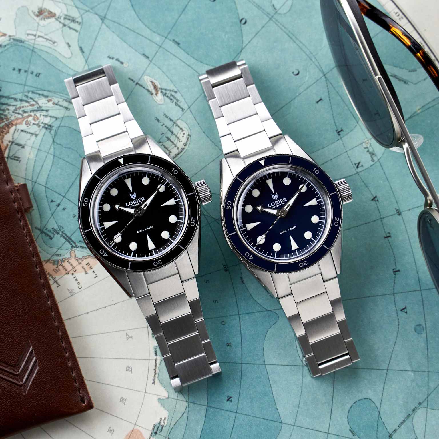 Two Lorier Neptune watches, featuring black and blue dials, showcased on a vintage-style map