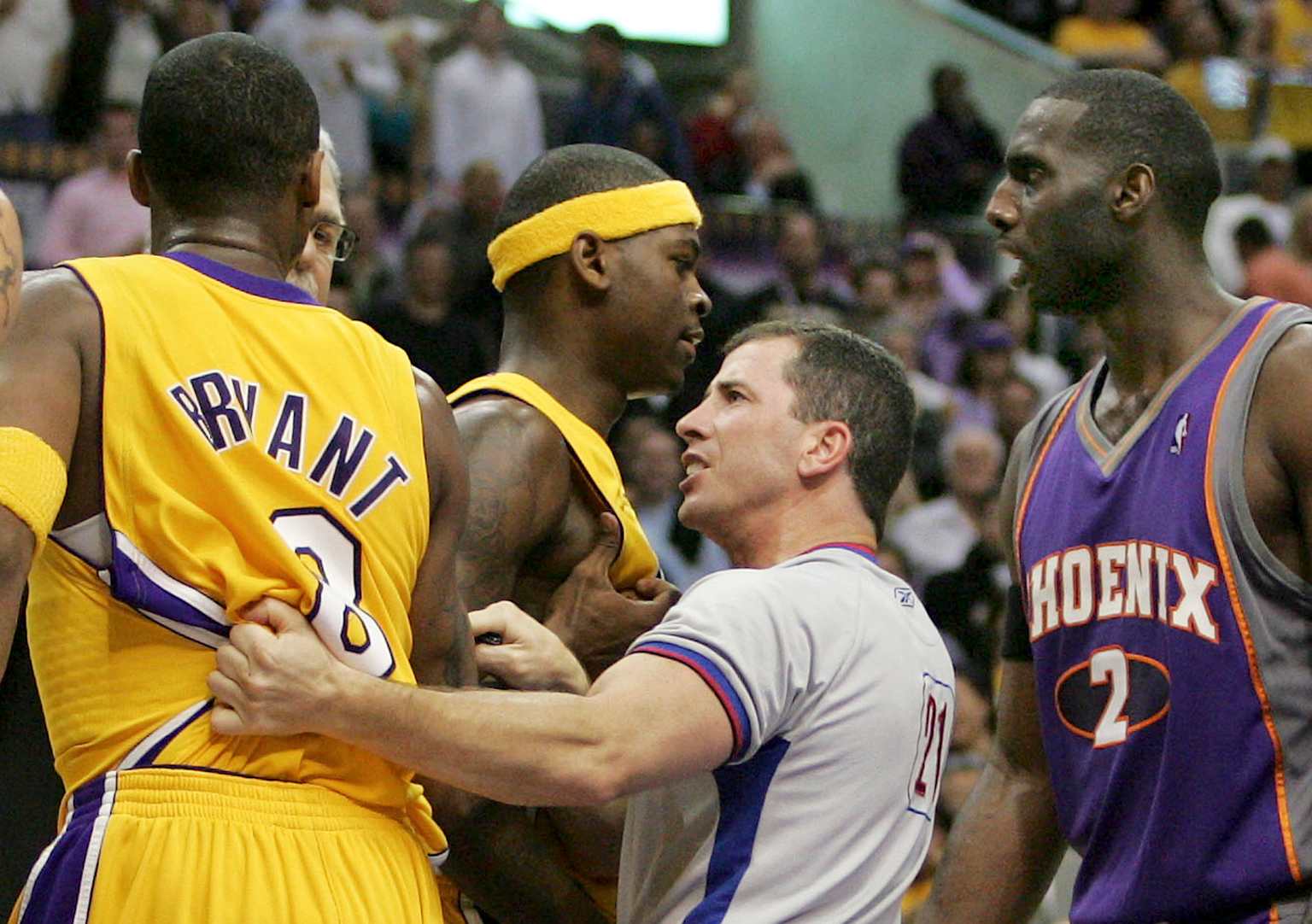 An NBA referee intervenes during a heated moment between players on the court