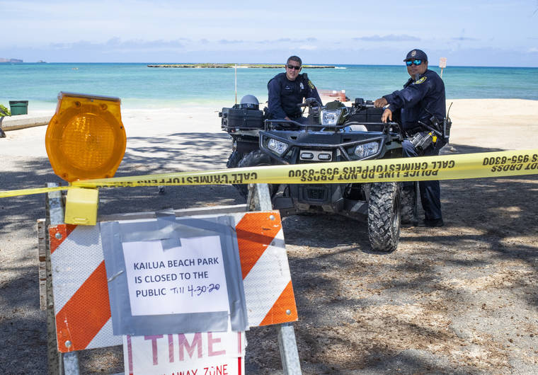 Honolulu police officers enforcing a beach park closure at Kailua Beach Park