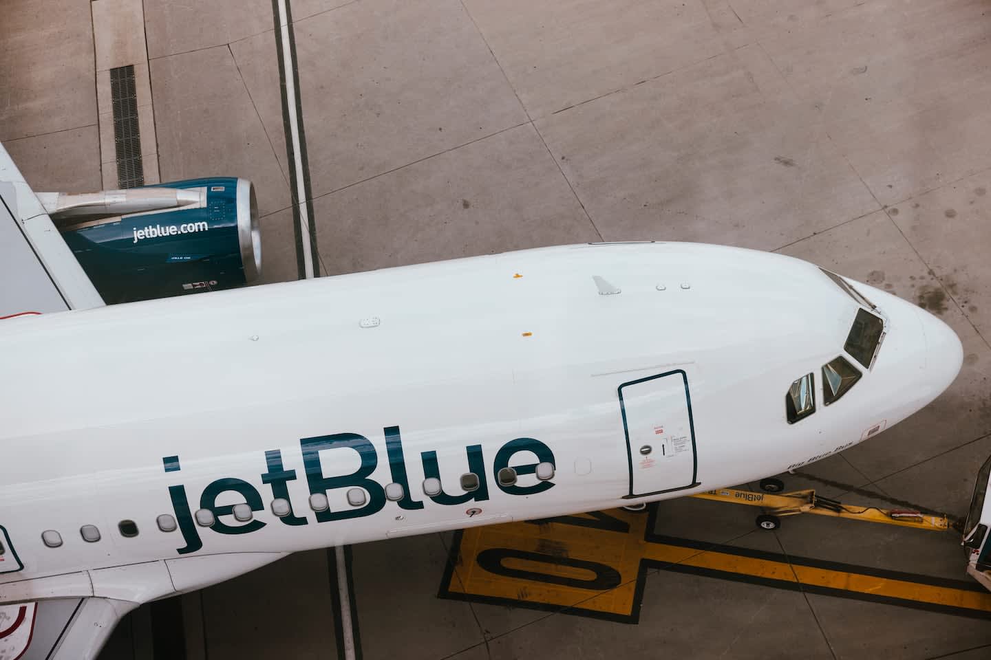 An overhead view of a JetBlue aircraft parked on an airport tarmac