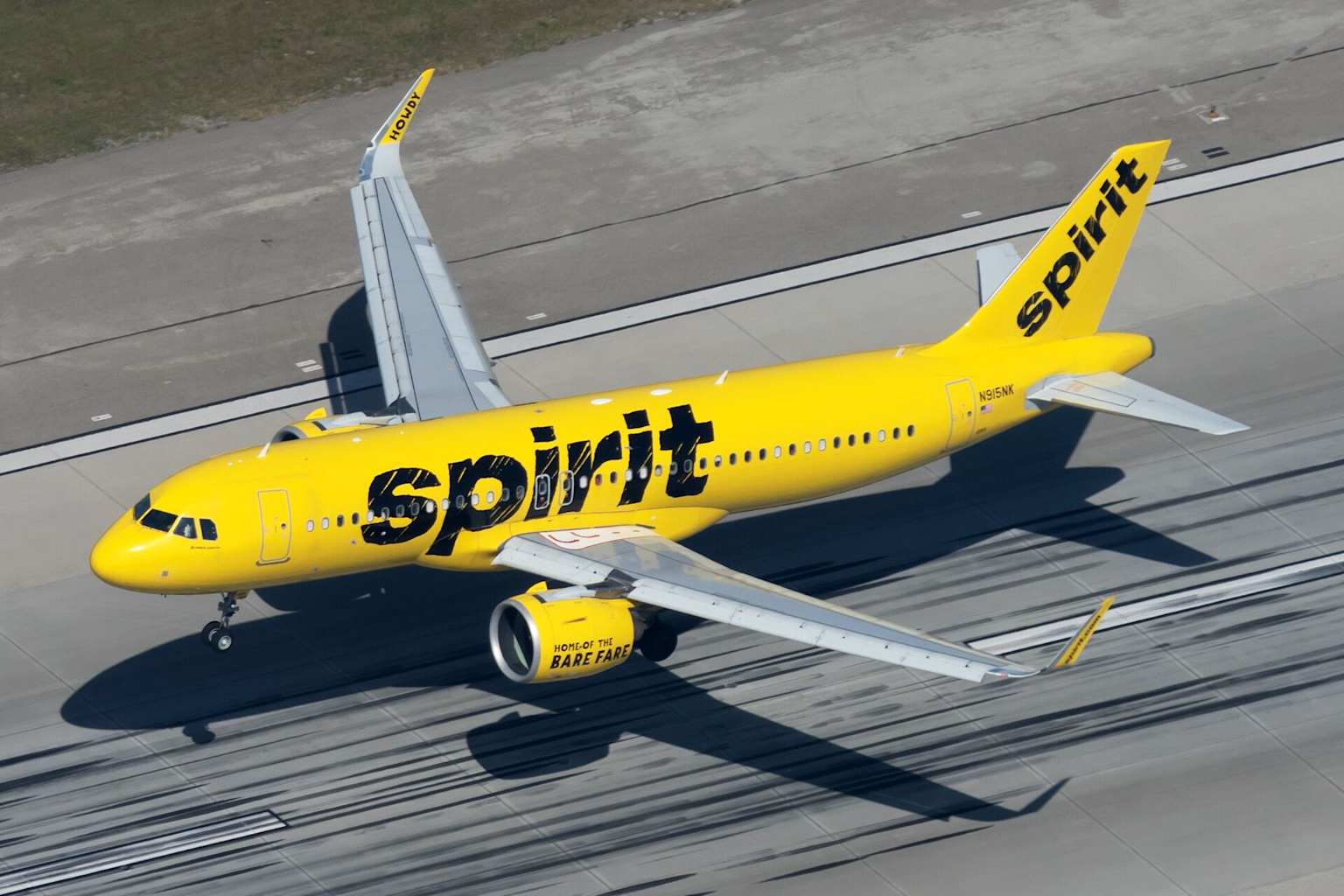 A bright yellow Spirit Airlines aircraft on the tarmac, showcasing its distinctive livery and branding