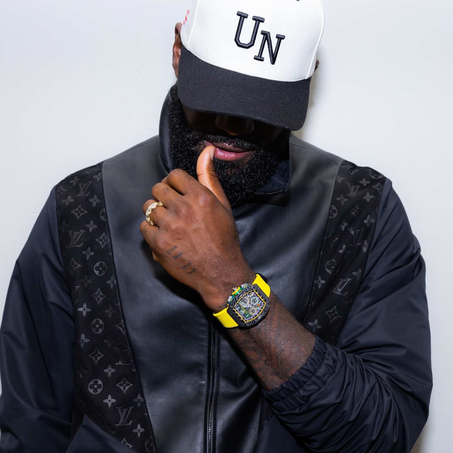LeBron James sporting a vibrant yellow-strapped Richard Mille watch with a black Louis Vuitton jacket