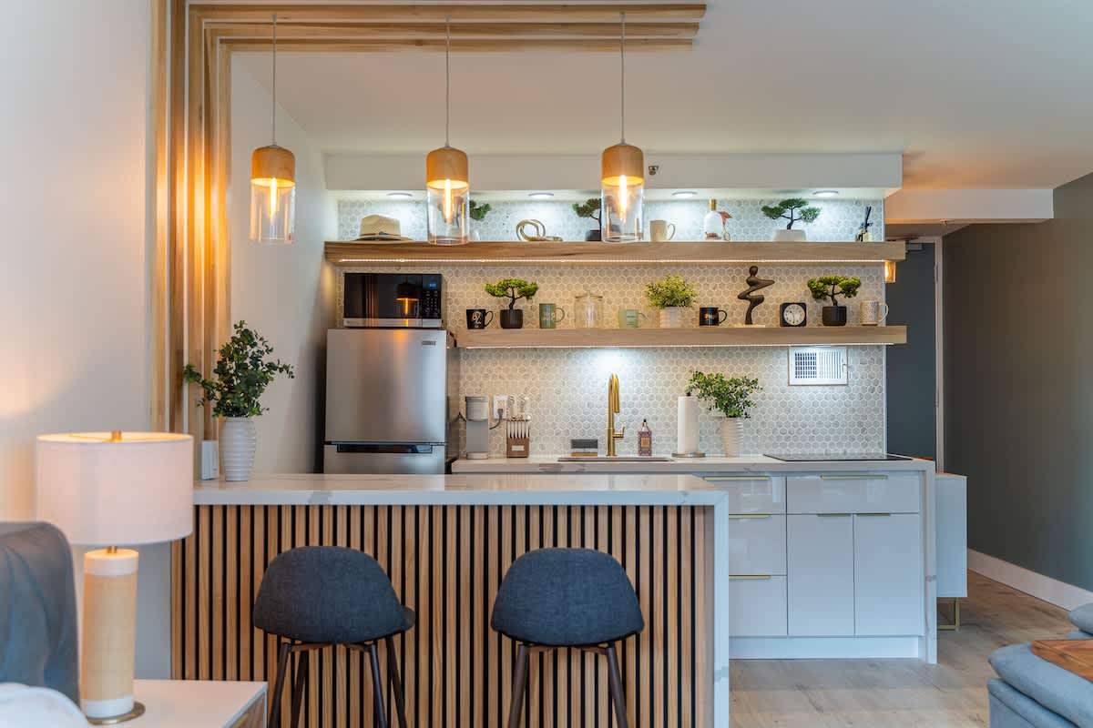 A modern kitchen and bar area within a vacation rental, showcasing amenities often found in an Airbnb or condo