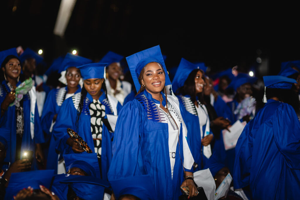 Young African university graduates celebrating in blue caps and gowns