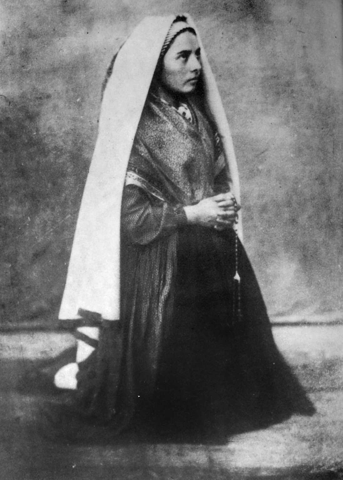 Bernadette Soubirous kneeling in prayer, captured in an 1861 portrait