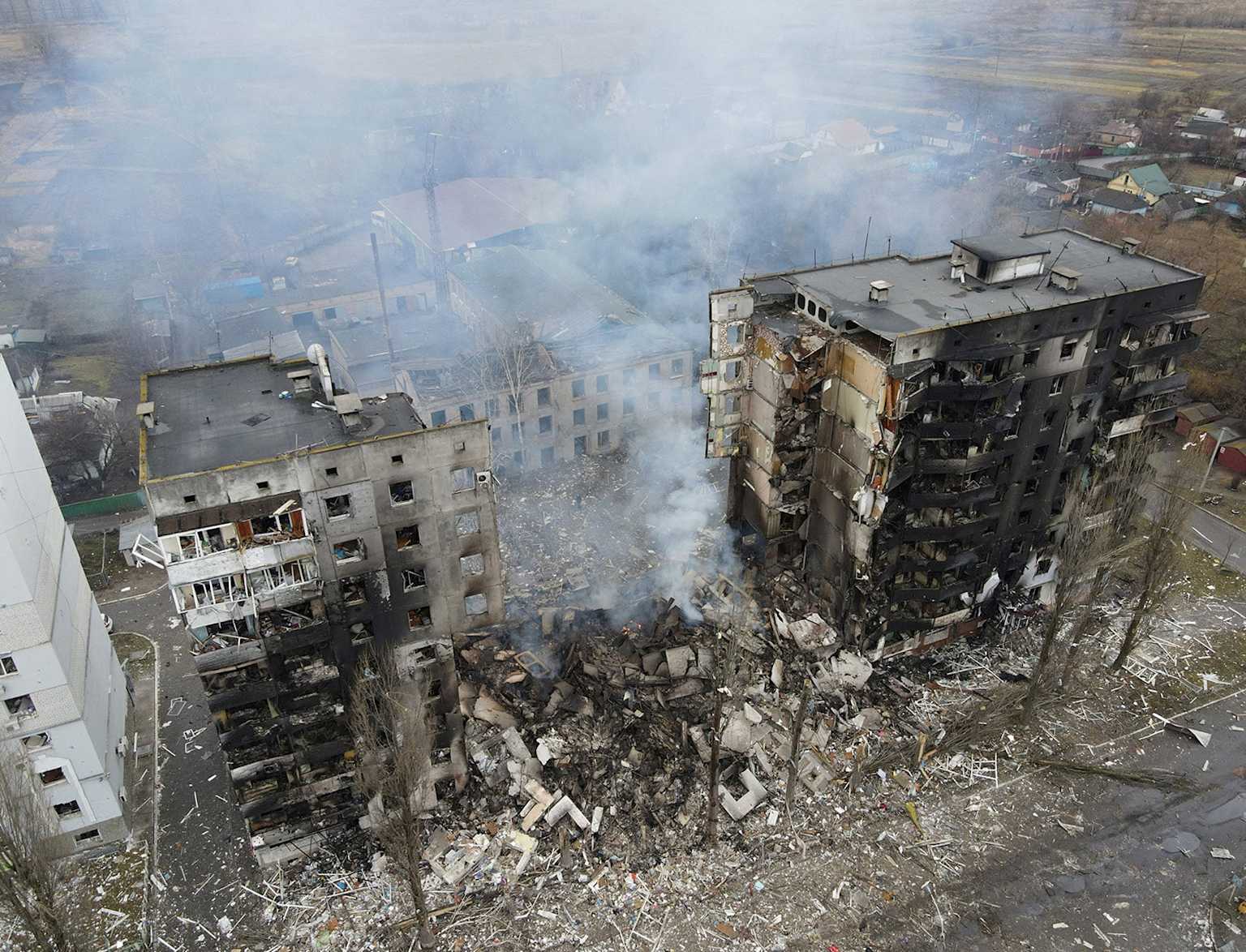 Aerial view showing severely damaged apartment buildings and extensive rubble in a Ukrainian urban area, a result of the ongoing conflict