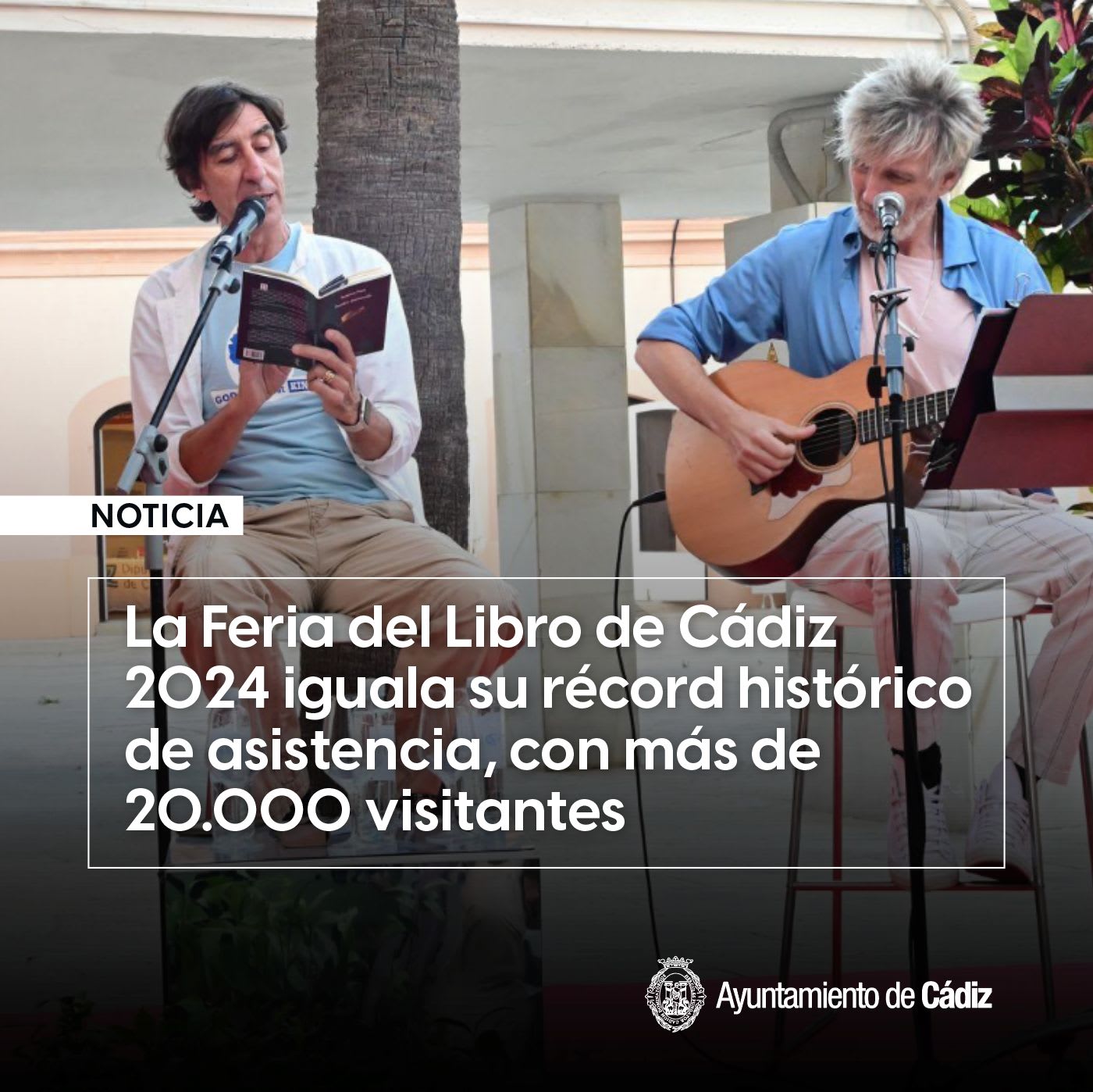 A man reads from a book into a microphone while another plays an acoustic guitar at the Cádiz Book Fair