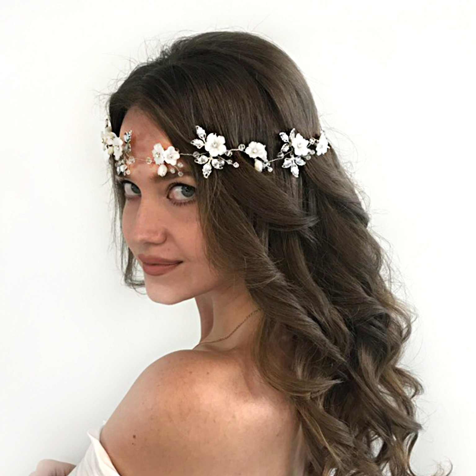 Delicate floral and beaded headpiece adorning a bride's long, wavy hair, perfect for a boho wedding style