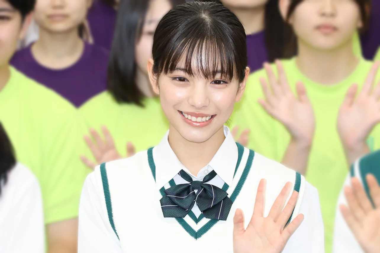 Actress Ami Touma smiling and waving in a school uniform
