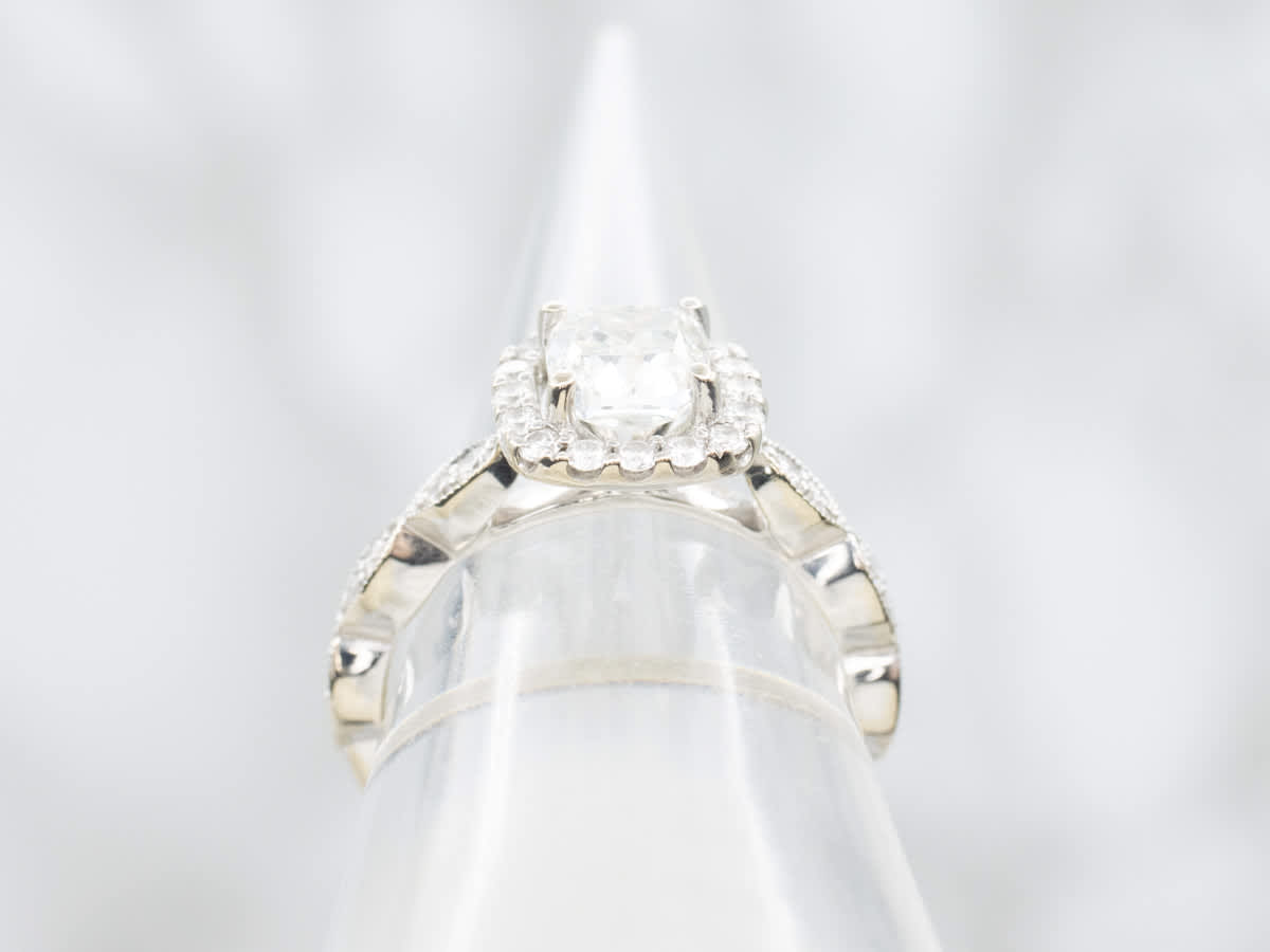 A sparkling cushion-cut diamond engagement ring with a halo setting displayed on a stand