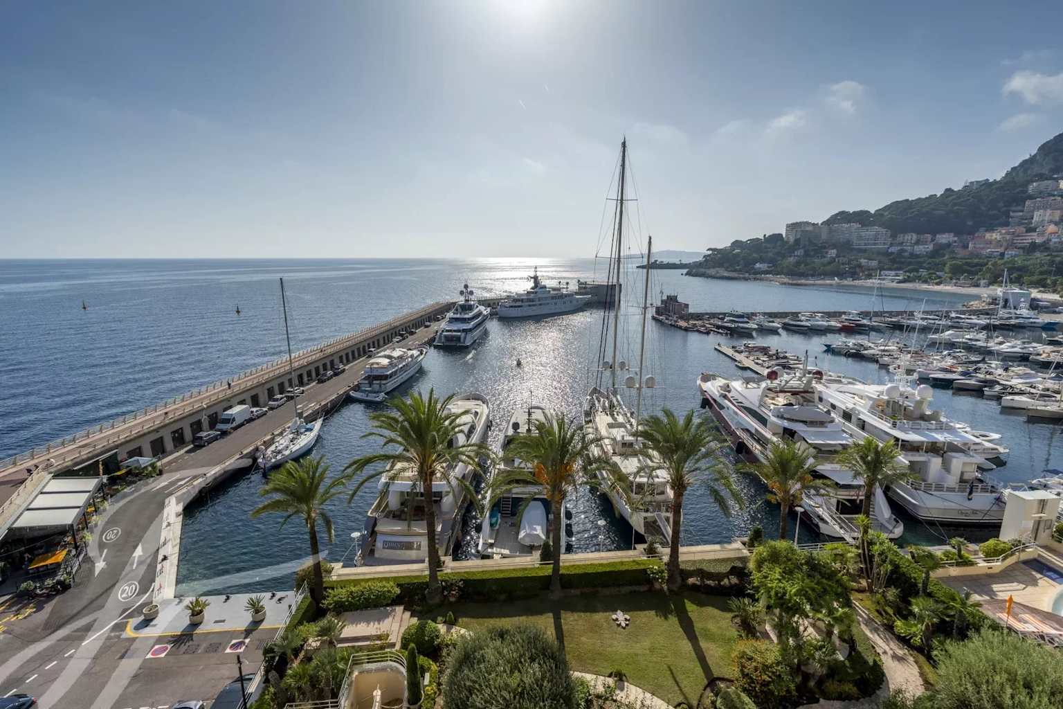 A panoramic view of Monaco's Port Hercule, showcasing luxury yachts and the city's high-end coastal real estate