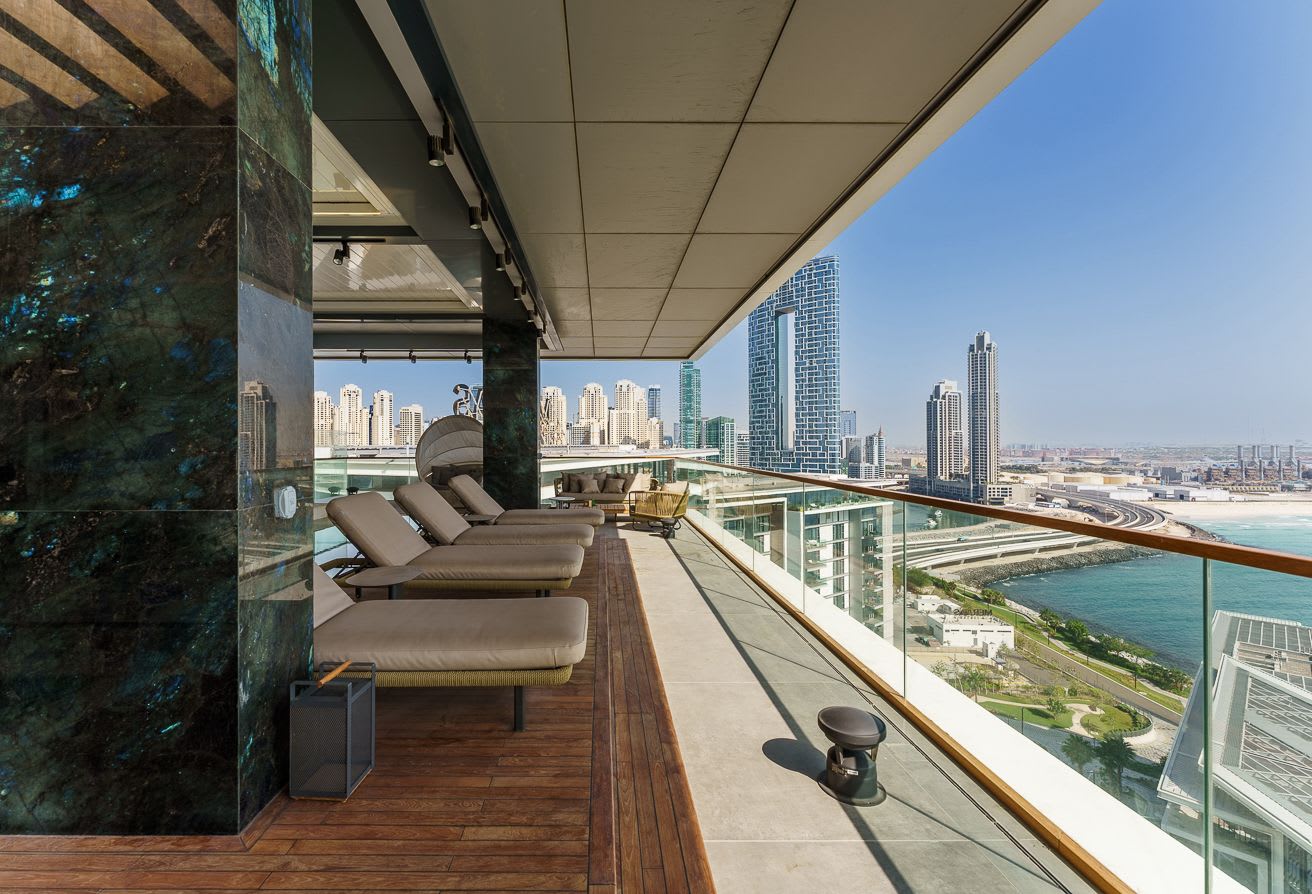 A luxurious penthouse terrace offering expansive views of the Dubai coastline and cityscape, emblematic of ultra-luxury properties