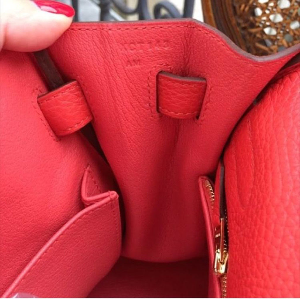 A close-up of a blind stamp on the interior leather of an Hermès bag, used for authentication