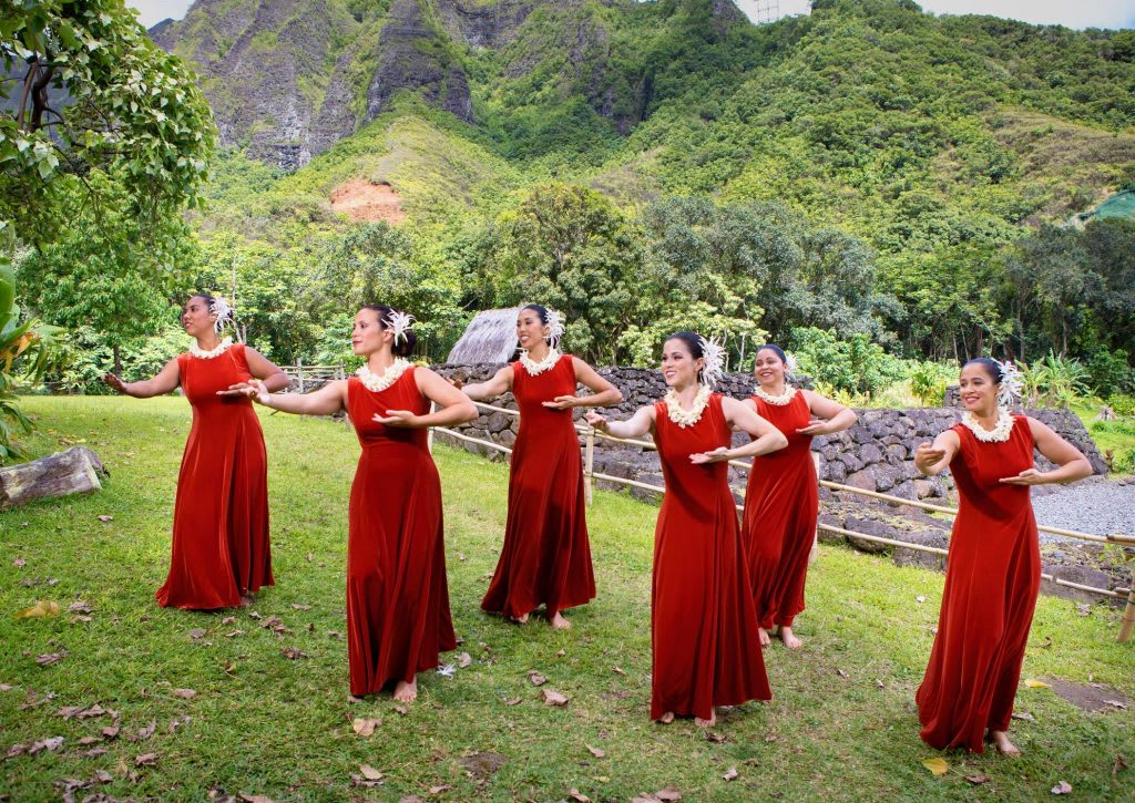 Hawaiian women performing a traditional hula dance in a lush outdoor setting showcasing authentic local culture