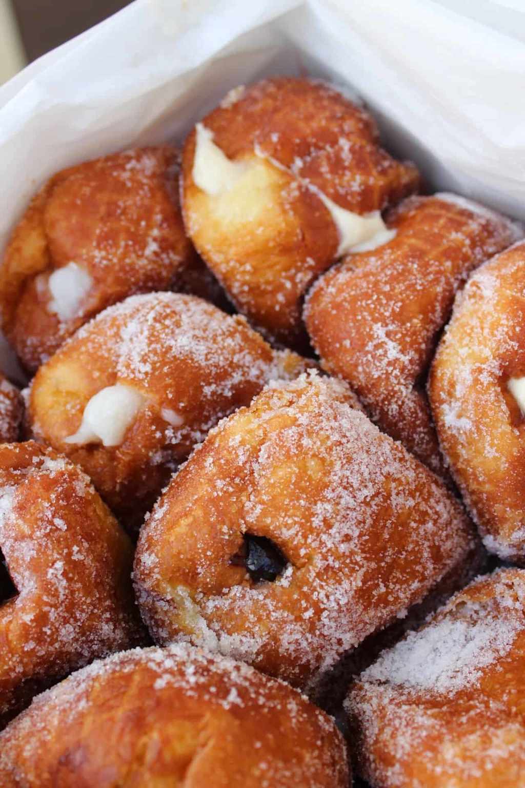 Close-up of Leonard's Bakery malasadas, a beloved Hawaiian Portuguese doughnut coated in sugar and filled with creamy custard