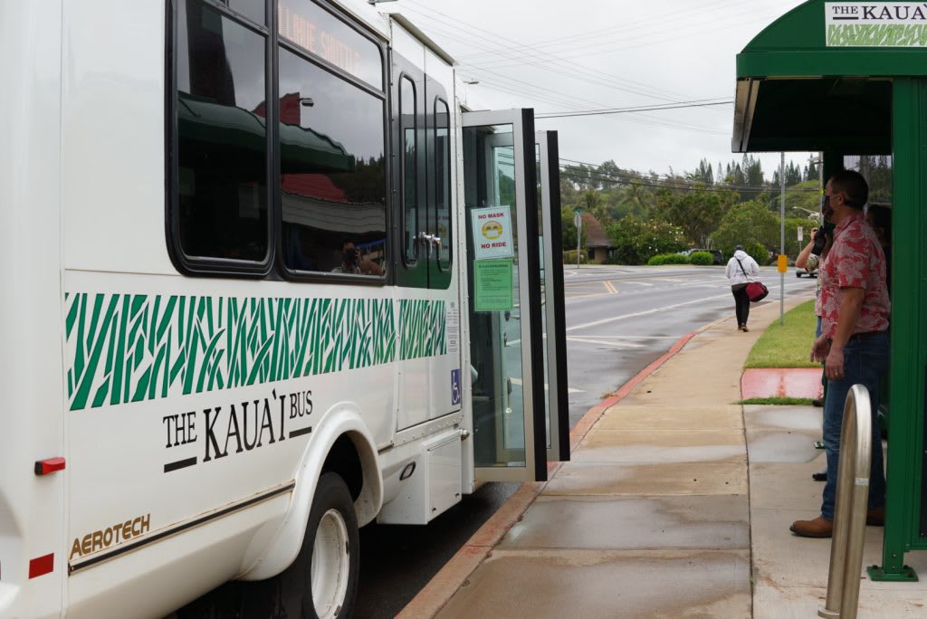 The Kaua'i Bus at a rural bus stop showing public transit as an alternative to car rentals on Kauai