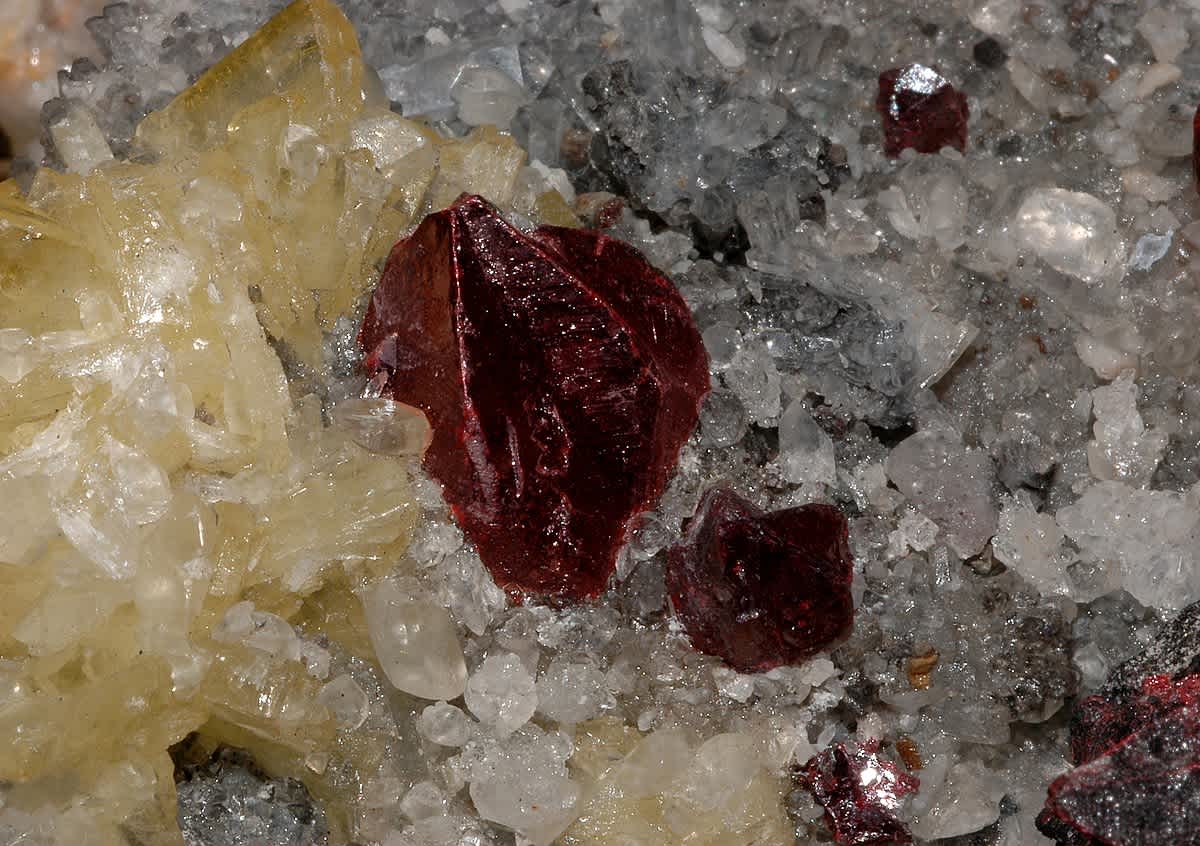 Close-up of red cinnabar-like crystals among other minerals, illustrating substances used in Chinese external alchemy (waidan)