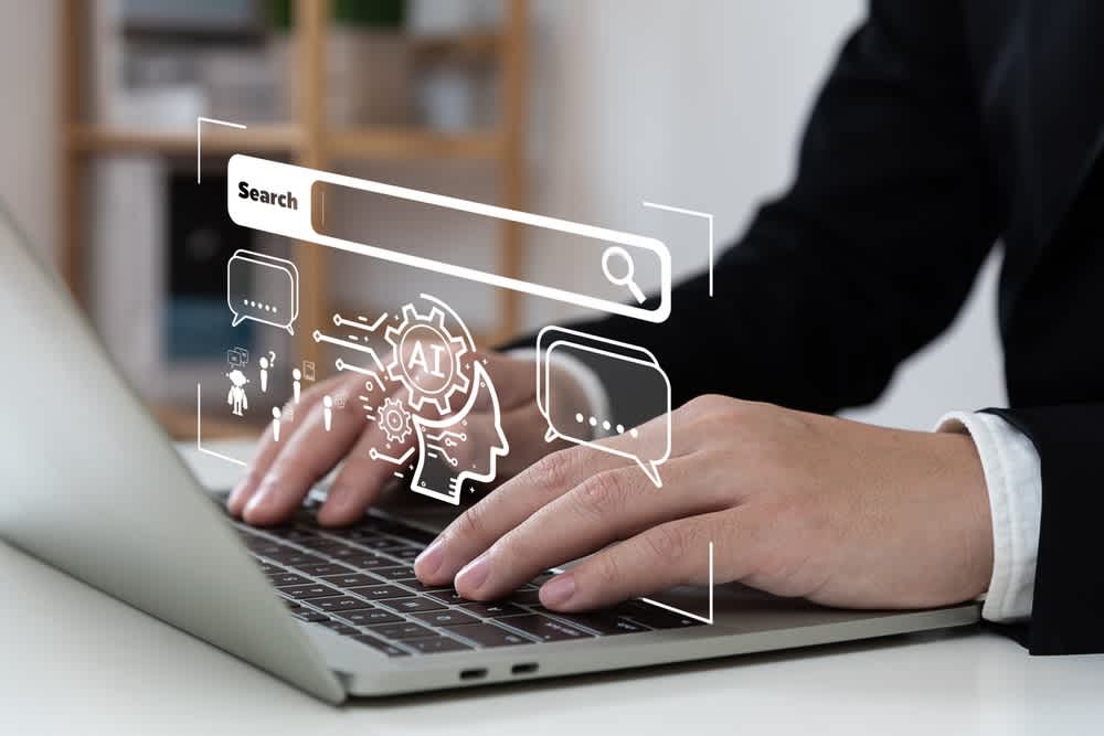 Hands typing on a laptop with digital AI and search graphics symbolizing technology-driven staffing solutions and digital transformation.