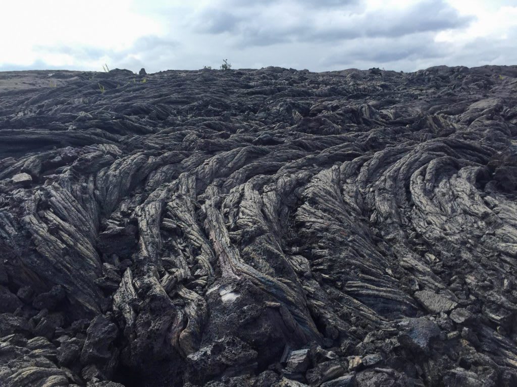 Hardened pahoehoe lava flow at Hawai'i Volcanoes National Park on the Big Island, illustrating the rugged volcanic terrain travelers may explore by car