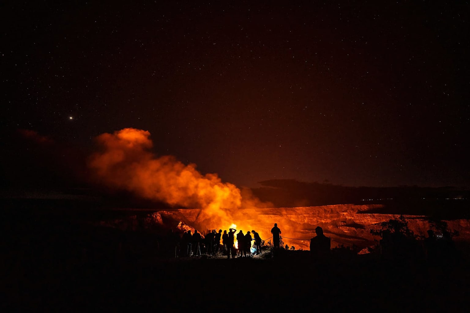 Nighttime lava glow at Kilauea volcano on Hawaii's Big Island with visitors watching the eruption