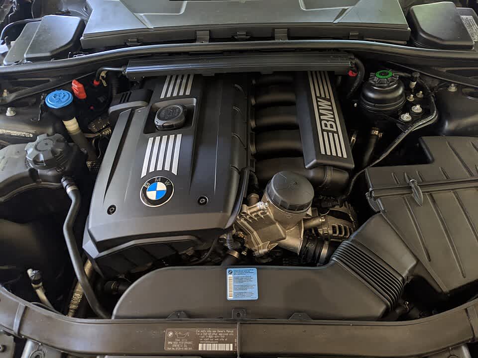 BMW E90 engine bay featuring the N52 engine with BMW branding clearly visible