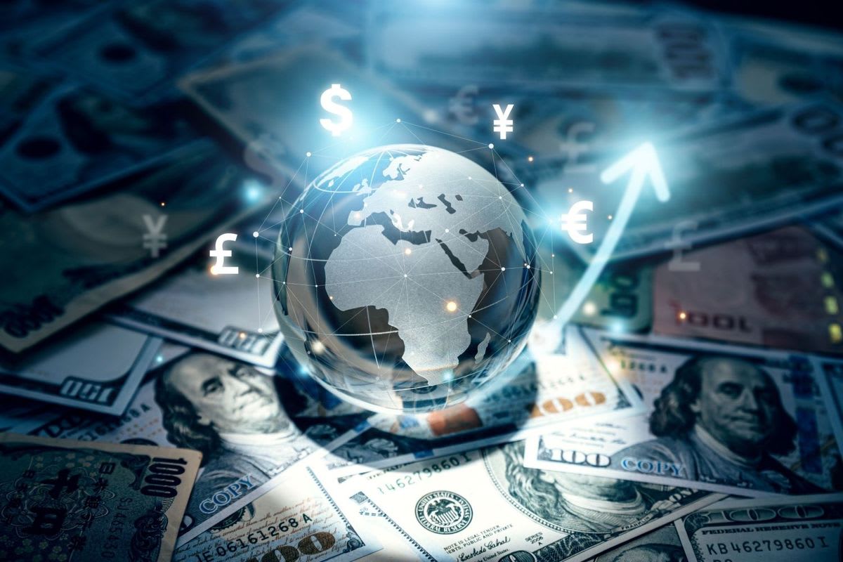 A globe surrounded by currency symbols and banknotes illustrating global investing and financial diversification